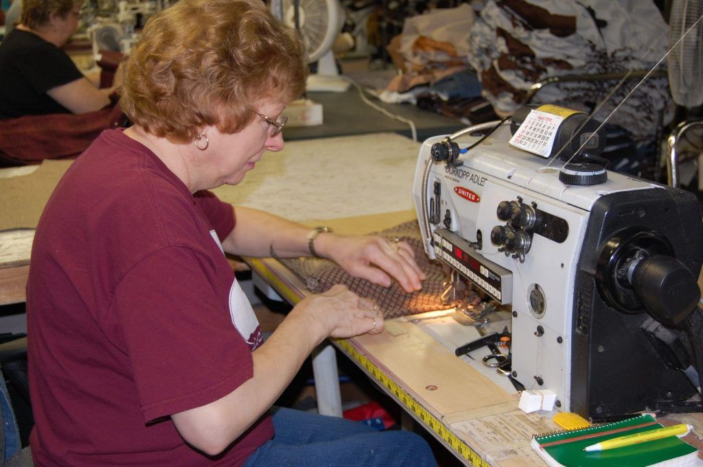 Golden Tech employee sewing fabric